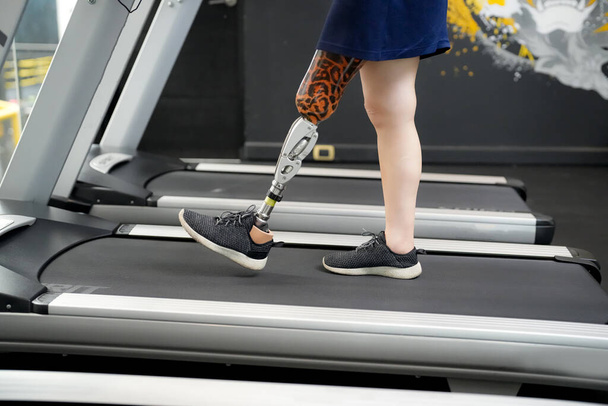 Retrato de mujer atleta discapacitada con pierna protésica en gimnasio - Foto, Imagen