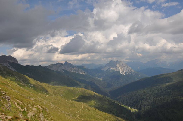 A beautiful landscape of big mountains of the Alps in Italy under the cloudy sky during the daytime - Фото, зображення