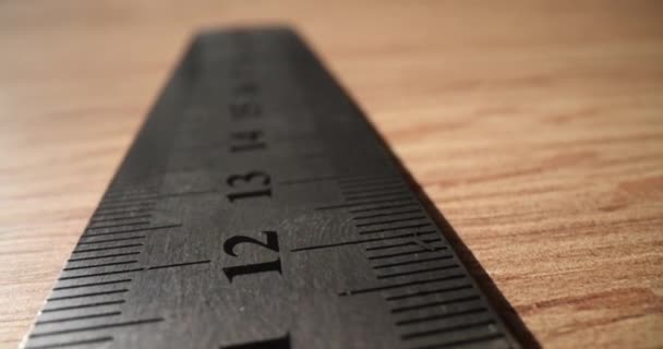 Metalen liniaal met cijfers en lijnen voor het meten van de lengte op houten tafel. Reparateur van de lokalen gereedschap op het bureau in de kamer. Instrumenten van de voorman - Video