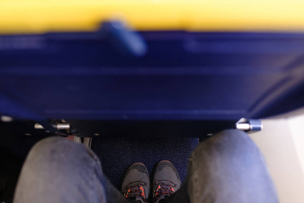 Image verticale d'un siège d'aéronef étroit et de petite taille. Problème d'ajustement des jambes. Il est conçu pour les voyageurs à petit budget qui ne craignent pas de sacrifier le confort pour l'abordabilité au lieu de l'espace pour les jambes. - Photo, image