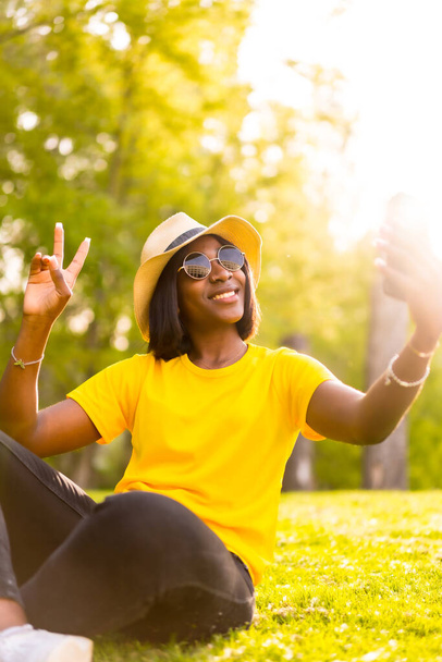 Summer Memories: Black Female Tourist Enjoying the Sunset with a Selfie - Photo, Image
