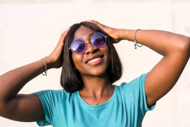 Posing for the Camera: Stylish Black Female Tourist in Green Top and Sunglasses - Фото, изображение