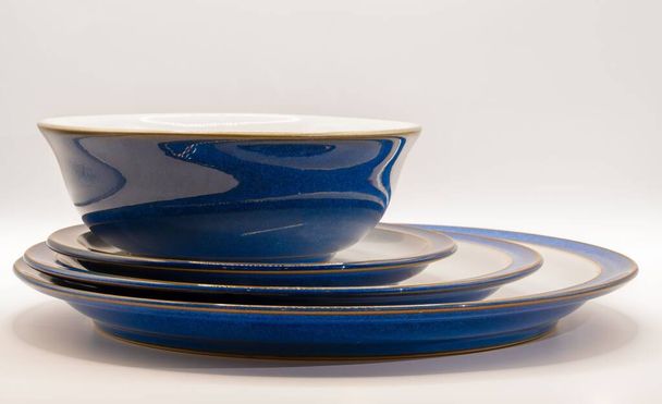 A bowl and three crockery plates of white and blue colors - Fotoğraf, Görsel
