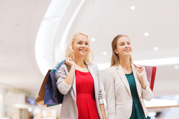 heureux jeunes femmes avec des sacs à provisions dans le centre commercial
 - Photo, image