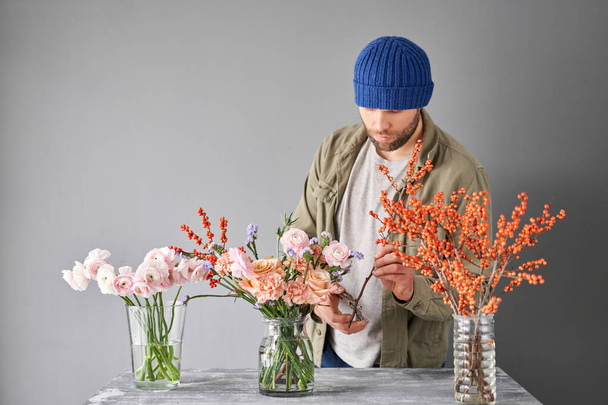 Portret van een mannelijke bloemist. Bloemen bos, klaar voor thuis. Verse snijbloemen voor decoratie thuis. Europese bloemenwinkel. Levering verse snijbloem - Foto, afbeelding