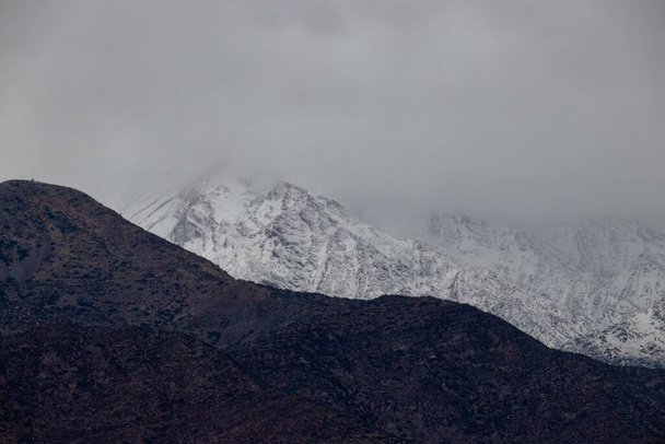 The Andes mountain range covered in snow on a foggy day in Santiago, Chile - Foto, Bild