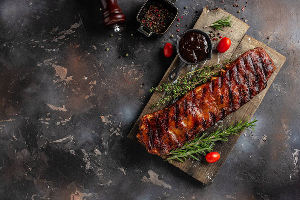 Spicy rack of spare ribs with marinade on a wooden board, banner, menu, recipe place for text, top view. - Valokuva, kuva
