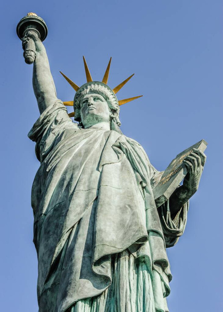A vertical shot of the Statue of Liberty on the background of the bright blue sky - Foto, afbeelding