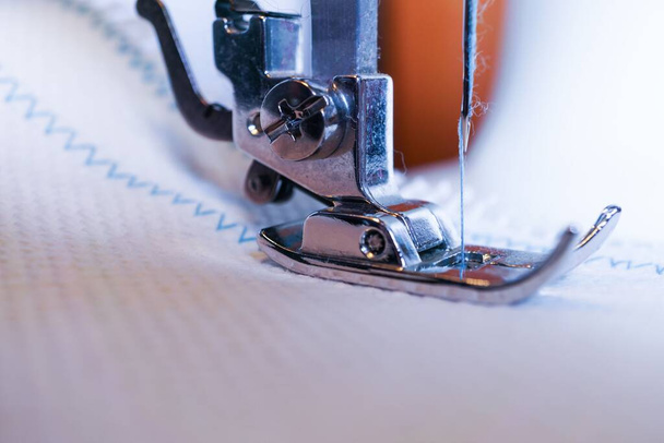close-up da agulha da máquina de costura com costura de linha azul em um tecido branco - Foto, Imagem