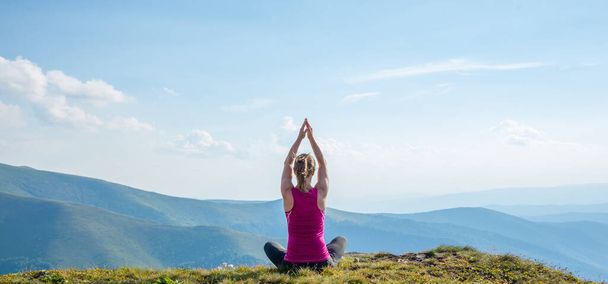 Young woman meditate on the top of mountain - Foto, imagen