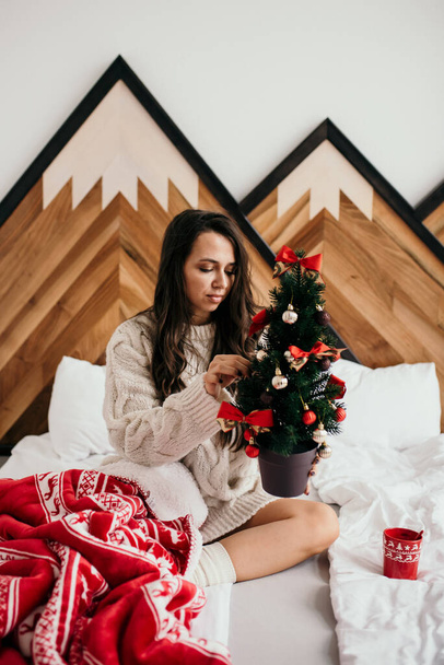 A fashionable woman in a cozy room in Christmas mood - Foto, afbeelding