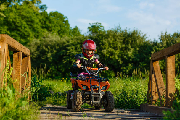 Little girl riding ATV quad bike in race track - Photo, Image
