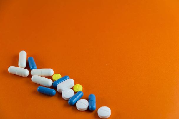 Stacked pills on orange color background. Medical supplies. - Foto, Imagen