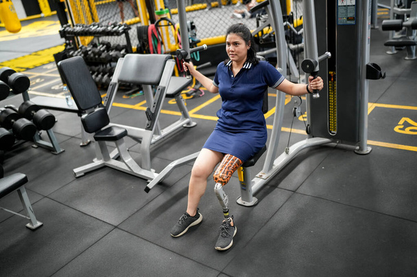Портрет спортсменки-инвалида с протезной ногой в фитнесе. Крупный план на бионической протезной ноге. - Фото, изображение
