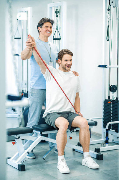 Physical therapy. Young man having a physical therapy session with a doctor - Foto, Bild