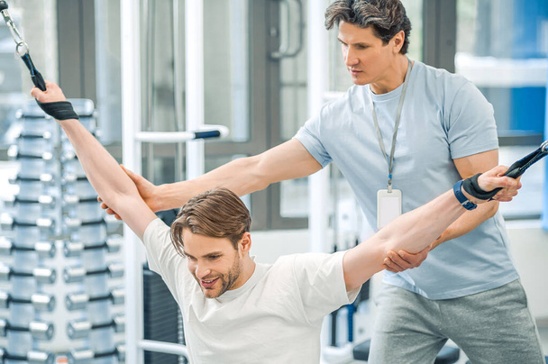 Hyperextension. Physical therapist assisting a patient while exercising on hyperextension - Фото, зображення