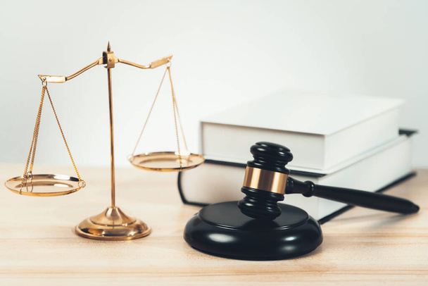 Symbolizing justice and legal authority, golden balanced scale and gavel on desk with law book in lawyer office background, reflecting concept of equality and fair judgment. equility - Photo, Image