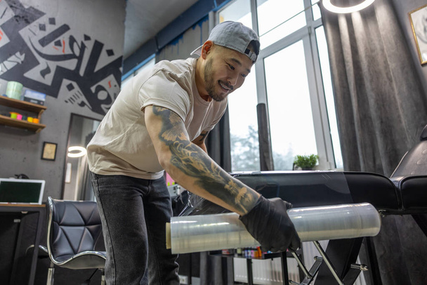 In the tattoo salon. Young man preparing for tattoo session - Fotografie, Obrázek