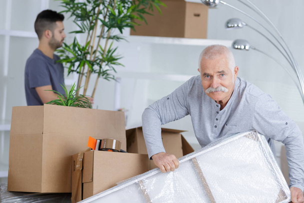 portrait of elderly man preparing belongings to move house - Foto, Bild