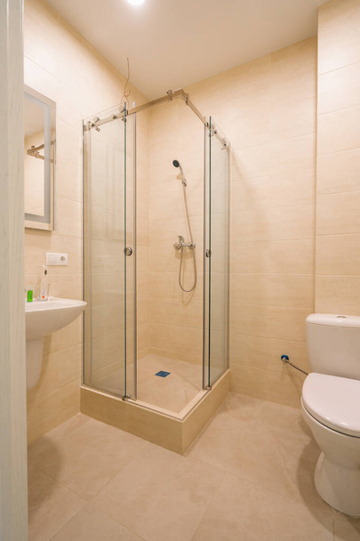 um banheiro em uma clínica de internação moderna um banheiro uma cabana de chuva uma pia um espelho um interior do banheiro - Foto, Imagem