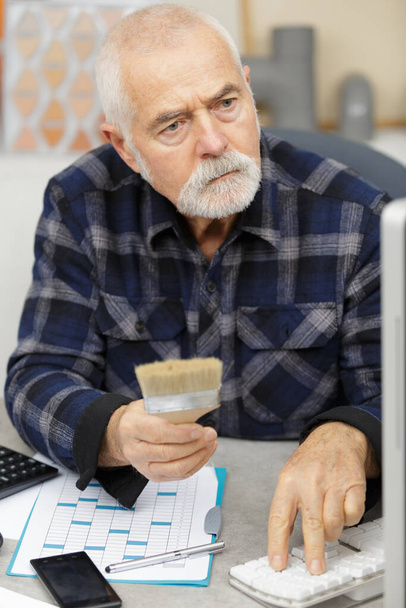 senior older professional holding a paint brush - Zdjęcie, obraz