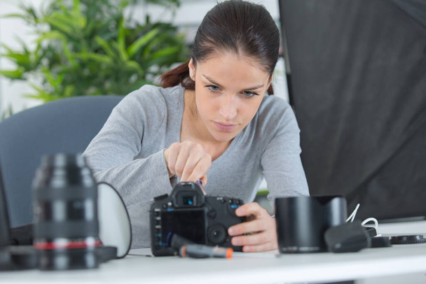 a female technician cleaning cameras - Photo, Image