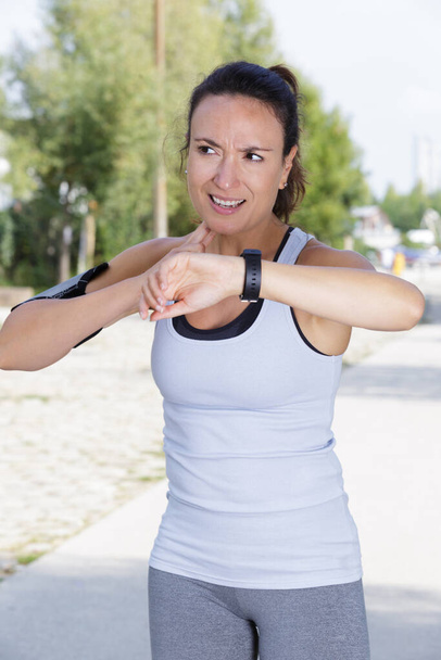 female runner measuring heart rate outdoors - Foto, imagen