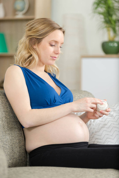 pregnant woman applying cream on her belly - Photo, Image