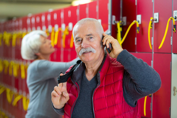 elderly man on phone in a locker room - Foto, Bild