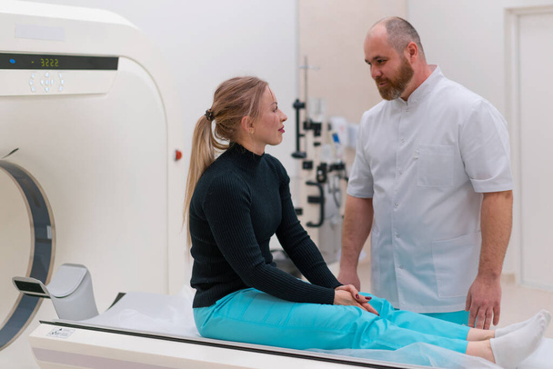 Врач консультирует пациента в медицинской клинике перед рентгеновской компьютерной томографией - Фото, изображение