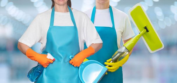 Group of cleaning ladies with mop and cleaning products on blurred background. - Φωτογραφία, εικόνα