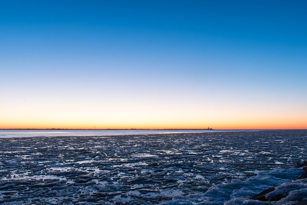 puesta de sol sobre el mar congelado
 - Foto, Imagen