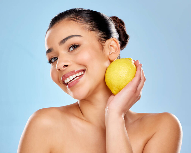 Schoonheid is mijn zaak. Studio portret van een aantrekkelijke jonge vrouw poseren met een citroen tegen een blauwe achtergrond - Foto, afbeelding