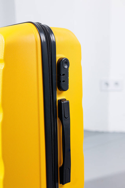 白い背景に荷物を運ぶための黄色のプラスチック製の強いスーツケース。旅行のための明るいスーツケース - 写真・画像