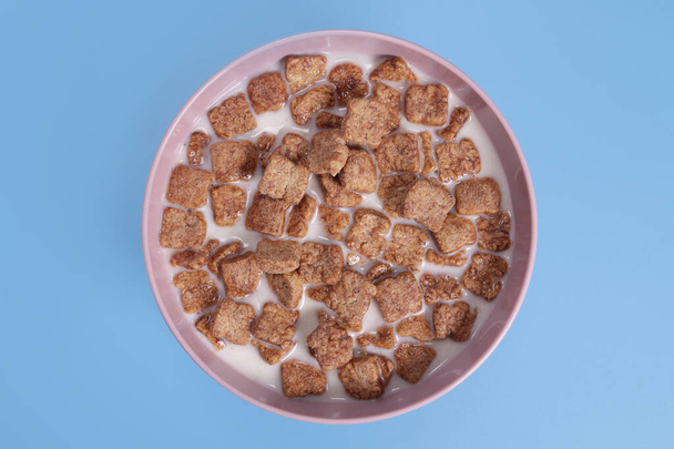 almofadas de milho com leite café da manhã saudável na tigela em fundo azul - Foto, Imagem
