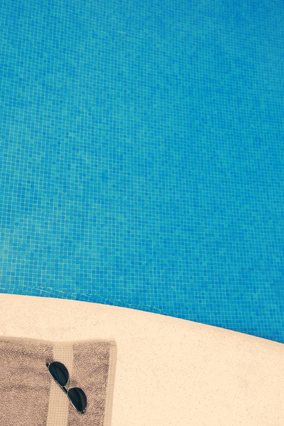 Handdoek en zonnebril bij zwembad - Foto, afbeelding