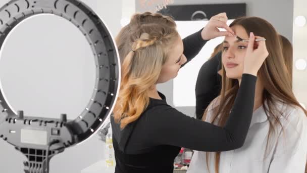 The eyebrow design master measures and corrects the shape of the eyebrows, creating symmetry and harmony. Dynamic frame showing the process of adjusting the shape of eyebrows with tweezers, giving - Footage, Video