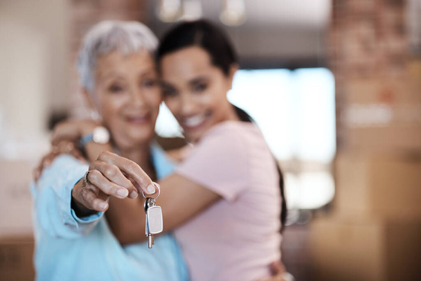 What makes a home are the memories made in it. a senior woman standing next to her daughter and holding up the keys to her new home - Photo, Image