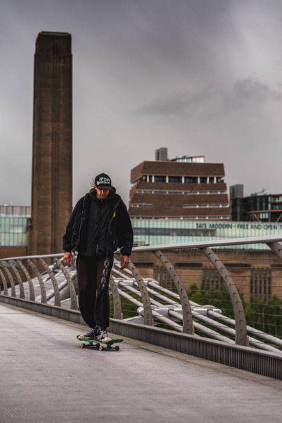 A young male skateboarding through Millennium Bridge, London, United Kingdom - Photo, image