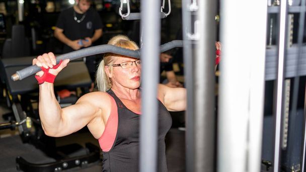 A Caucasian muscular woman training at the gym. - Valokuva, kuva