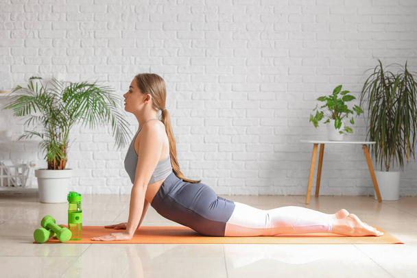 Jeune femme sportive faisant du yoga à la maison - Photo, image