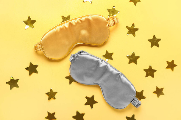 Μάσκες ύπνου και αστέρια σε κίτρινο φόντο - Φωτογραφία, εικόνα