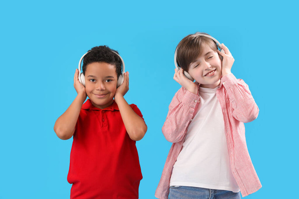 Kisfiúk fülhallgatóban, kék háttérrel. Gyermeknapi ünnepség - Fotó, kép