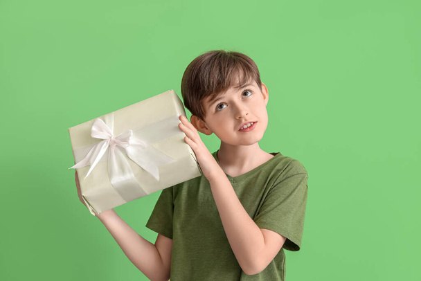 緑の背景に贈り物を持つ小さな男の子。こどもの日 - 写真・画像