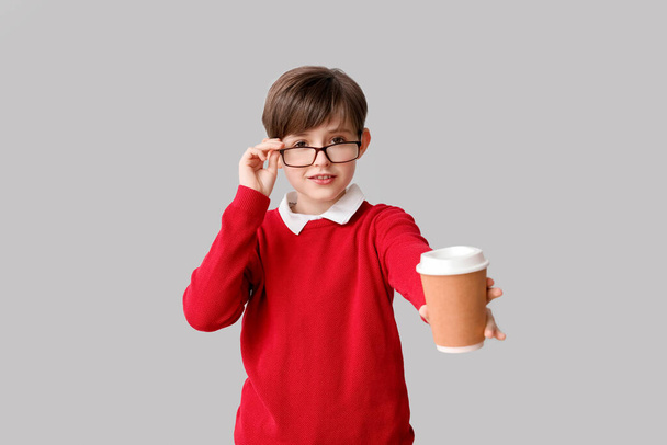 Маленький мальчик с чашкой какао на светлом фоне. Праздник Дня защиты детей - Фото, изображение