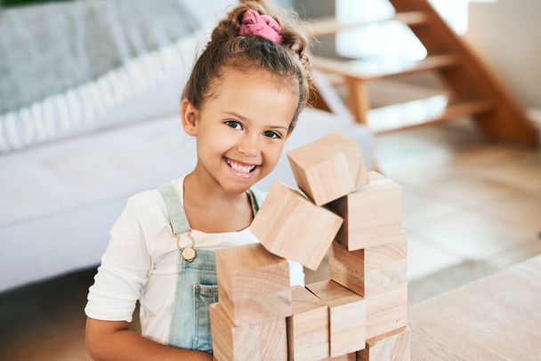 Just a little cutie enjoying some playtime. Portrait of an adorable little girl playing with wooden blocks at home - 写真・画像