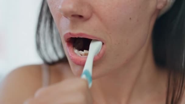 Процесс чистки зубов женщин крупным планом в ванной комнате. Половина портрета юная леди чистит зубы по утрам. Здоровый модель чистки рта с отбеливанием зубной пасты в одиночку в светлом доме. Концепция стоматологической помощи - Кадры, видео