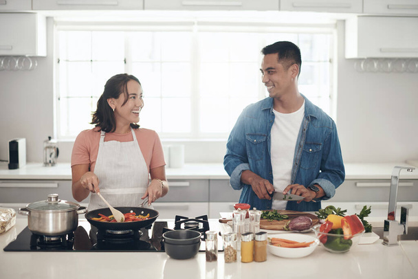 Gemeinsames Kochen stärkt die Bindung. Ein junges Paar kocht zu Hause zusammen - Foto, Bild