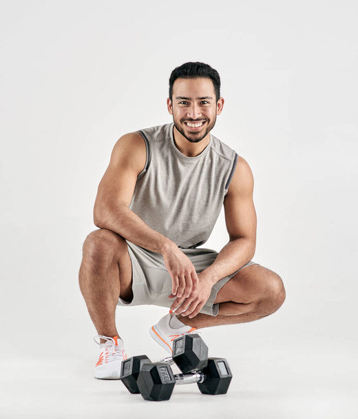 Dont throw in the towel - use it to wipe your sweat. Studio portrait of a muscular young man posing with dumbbells against a white background - 写真・画像