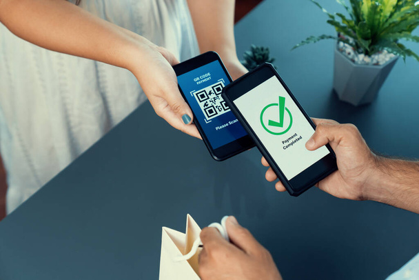 QR code displayed on screen for cashless payment scanning. Closeup hands hold smartphone to transfer money by electronic transaction from mobile app. Bar code technology for fast payment. Fervent - Photo, Image